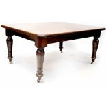 A Victorian mahogany wind-out dining table with canted corners and two extra leaves,