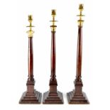 Three near matching ecclesiastical-style Classical column candlesticks,
