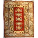 A Caucasian wool rug with rectangular central panel of five stylised floral medallions within