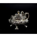 A George IV hallmarked silver ornate mustard pot with floral and foliate repoussé decoration,