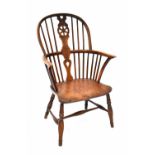 An elm seated Windsor chair with wheel vase splat and comb back,