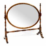 A mahogany oval swing toilet mirror on slender turned supports united by a stretcher,