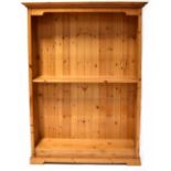 A pine floorstanding bookcase with a moulded top and five shelves, on bracket feet,