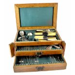 A George V oak canteen of cutlery with fitted interior of lift-up top and two drawers,
