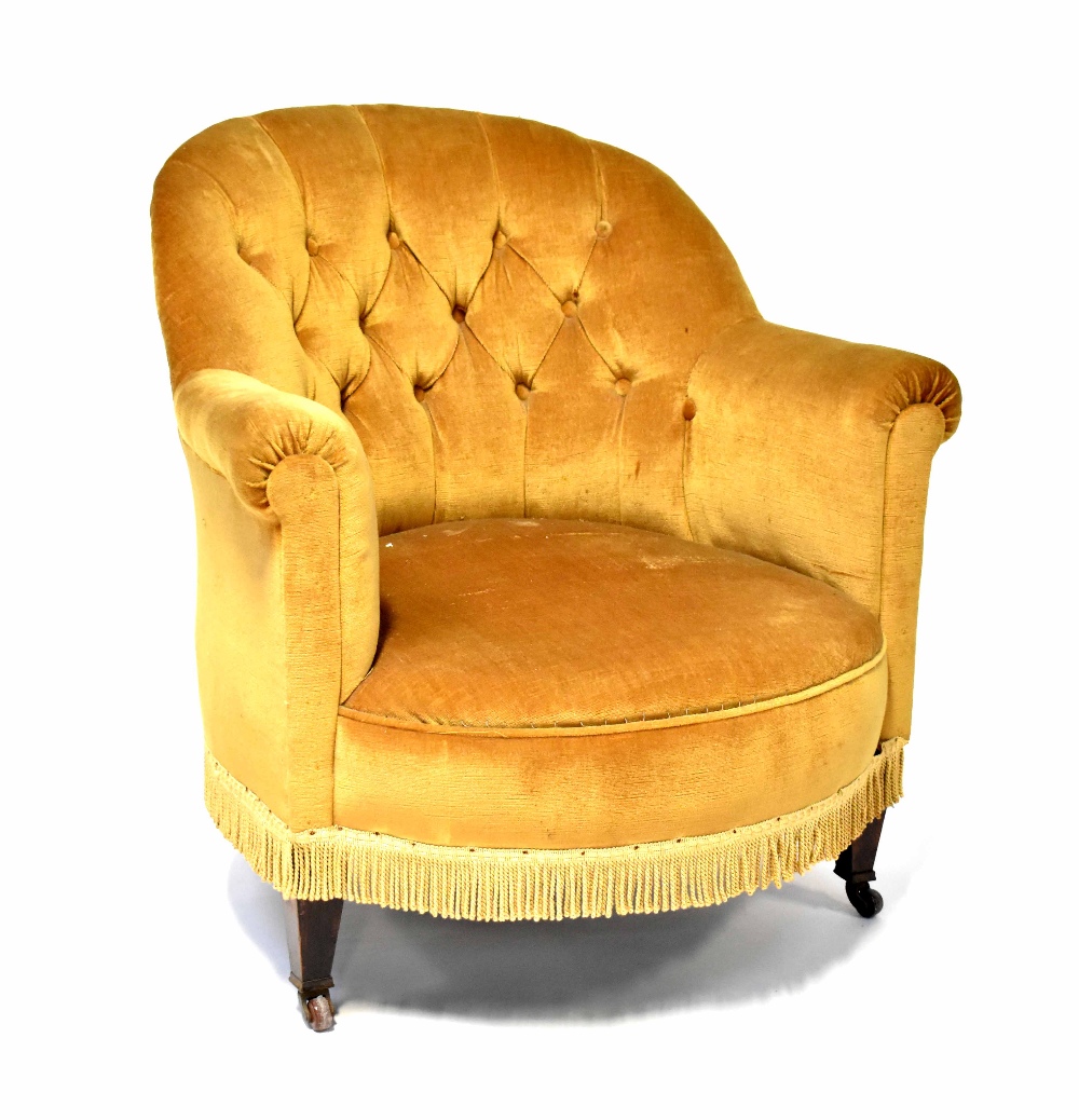 A 1930s mahogany-framed button-back tub armchair upholstered in mustard velour.