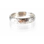 An 18ct white gold band ring with a repeating rose head pattern,