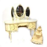 A modern French-style cream painted dressing table with glass inlaid kidney-shaped top fitted with