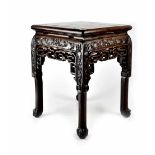 A Chinese carved hardwood low jardinière stand with inset rouge marble top above a carved frieze,