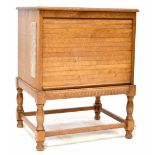 An oak television cabinet with tambour shutter front, on turned and block legs united by stretchers,