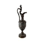 A 19th century bronze ewer with high loop handle and figure of a putto,