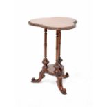 A reproduction mahogany trefoil-topped occasional table on three column supports with carved