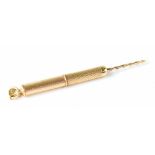 A hallmarked 9ct gold retractable twist end toothpick with engine turned body, Birmingham 1965,
