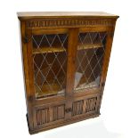 An oak Priory style bookcase/display cabinet, with pair of leaded glazed doors above pair of