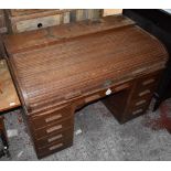 A large  early 20th century oak roll top desk, the tambour top above with an arrangement of nine