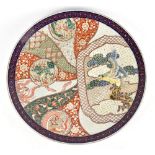 A Japanese Meiji period Imari wall charger, painted with stylised exotic birds and Shishi dog,