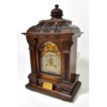 JUNGHANS; a late 19th century carved walnut mantel clock, the brass face with applied gilt detail