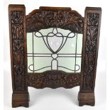 An Arts & Crafts carved oak firescreen with inset leaded glass panel, 80 x 68cm (glass af).