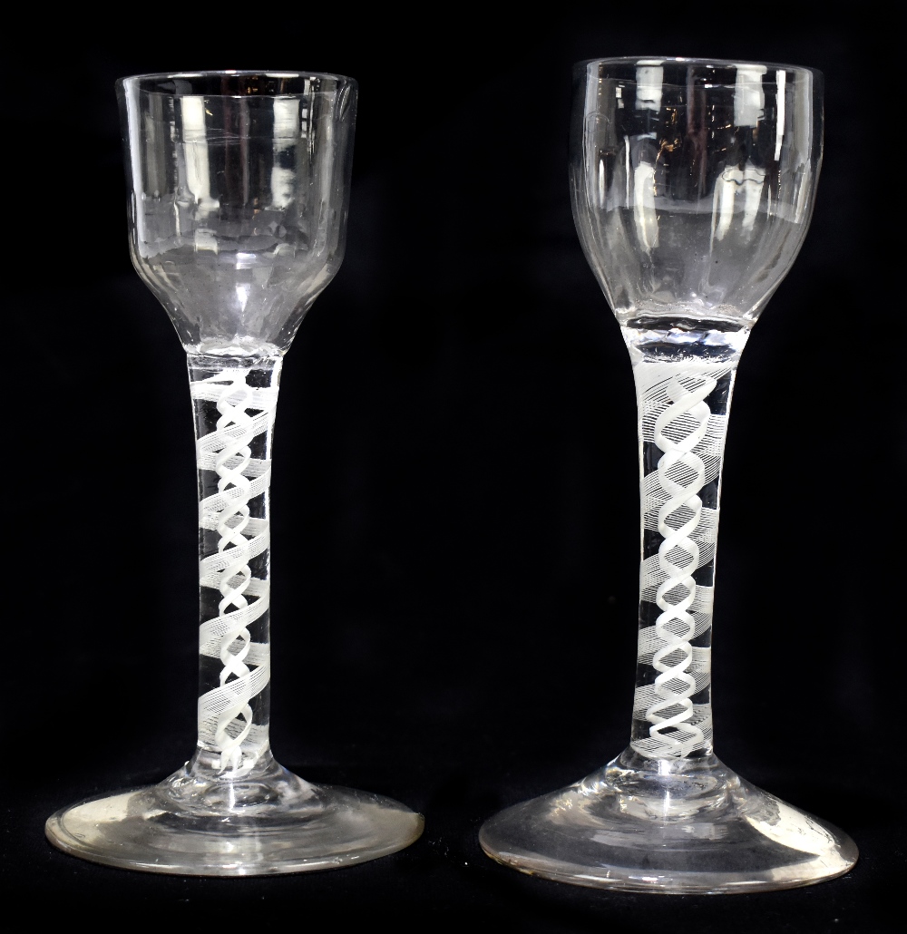 Two Georgian air twist wine glasses, the first with fluted ogee bowl, raised on opaque air twist