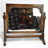 A carved oak framed swing toilet mirror.