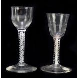 Two late 18th/early 19th century air twist wine glasses, the first with ogee bowl, raised on