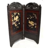 An early 20th century Japanese lacquer two division folding screen, with carved top panels above