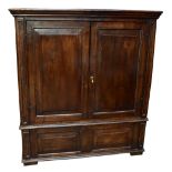 An 18th century and later oak press cupboard with pair of doors above panelled base, later hanging