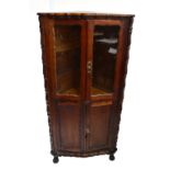 A reproduction South African hardwood corner cupboard with pair of glazed doors to upper section and