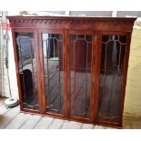 A reproduction mahogany bookcase with moulded cornice above four astragal glazed doors and a base of