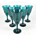 A set of six large Victorian green glass wine glasses on spreading circular feet, height of each