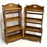 A near pair of open oak bookcases with pierced shaped backs above four shelves with open side