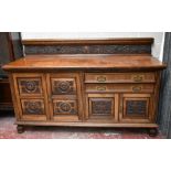 A large late Victorian pollard oak and oak sideboard, the raised back with scrolling carved detail