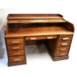 An early 20th century mahogany roll top desk, the shallow tambour top above twin pedestals, width