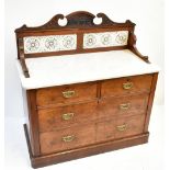 A Victorian walnut washstand with tiled back and white marble top above two short and two long