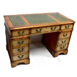 A reproduction pedestal desk (bleached) with inset gilt tooled writing surface above an