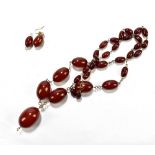 A strand of amber coloured beads, together with a matching earring, inset within base metal
