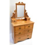 An Edwardian satin walnut dressing chest, the bevelled mirror back above two short and two long