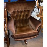 G-PLAN; a wing back upholstered swivel armchair on castors.Additional InformationUpholstery somewhat