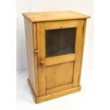 A pine single door cupboard with glazed upper section, panelled beneath and single shelf to the