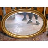 A gilt framed oval bevelled wall mirror, 88 x 62cm.