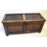 An early 18th century oak coffer, the panelled hinged lid above carved frieze and raised on stile