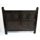 A late 18th century and later carved panelled oak headboard, height 122cm, length 142cm.Additional