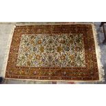 An Eastern hand knotted park silk and woollen rug, with elaborate foliate decoration within a