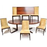 DYRLUND; a rosewood extending dining table with two extra leaves, raised on V-shaped block supports,