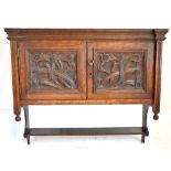 An Arts & Crafts oak hanging cupboard, with twin panel doors and carved floral detail, height