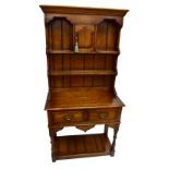 TAYLOR & CO LTD; a reproduction oak dresser of small size, the boarded plate rack with small