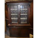 A late Victorian walnut bookcase with pair of leaded glazed doors above two drawers and two doors,