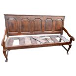 A 19th century oak settle, the five-panel back crossbanded in mahogany, on cabriole supports,