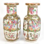 A pair of mid to late 19th century Chinese Canton Famille Rose Rouleau vases with panelled figural