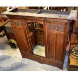 A large Arts & Crafts oak wardrobe with central bevelled mirror door flanked by carved and inlaid