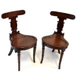 A pair of early 19th century mahogany hall chairs on turned supports.